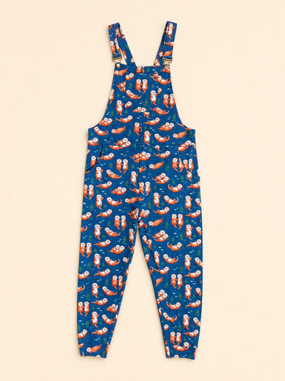 Blue overall jumpsuit with an all-over print of otters shown flat against a light beige background.
