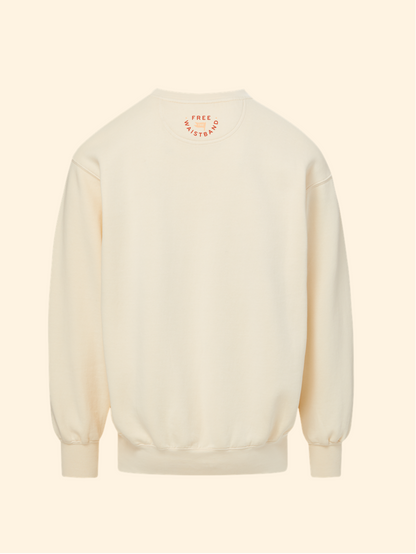 A cream-colored crewneck sweatshirt shown from the back, featuring a small circular graphic with the text 'FREE SKYTOPS' in orange around a central yellow sun motif.