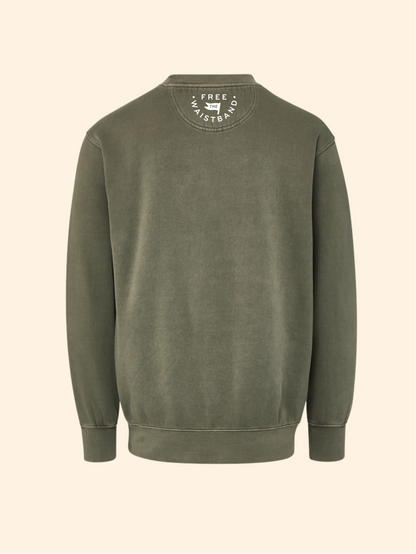 An olive green crewneck sweatshirt shown from the back, featuring a circular white graphic print on the inside of the collar, set against a solid cream background.