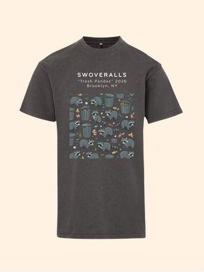 A dark charcoal gray t-shirt with a graphic print on the front. The print features the text 'SWOVERALLS Trash Pandas 2026 Brooklyn, NY' above a pattern of raccoons in a trash can with small colorful details.