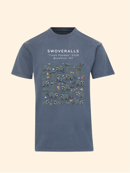 A slate blue crewneck t-shirt featuring a graphic print of trash pandas and recycling symbols with the text 'SWOVERALLS "Trash Pandas" 2026 Brooklyn, NY' on the chest, displayed against a solid cream background.