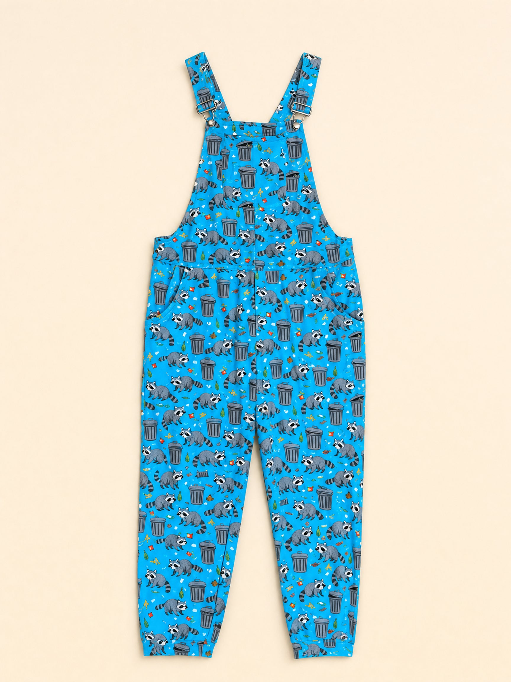 Bright blue overall jumpsuit with an all-over raccoon and trash can pattern, shown flat against a light beige background.