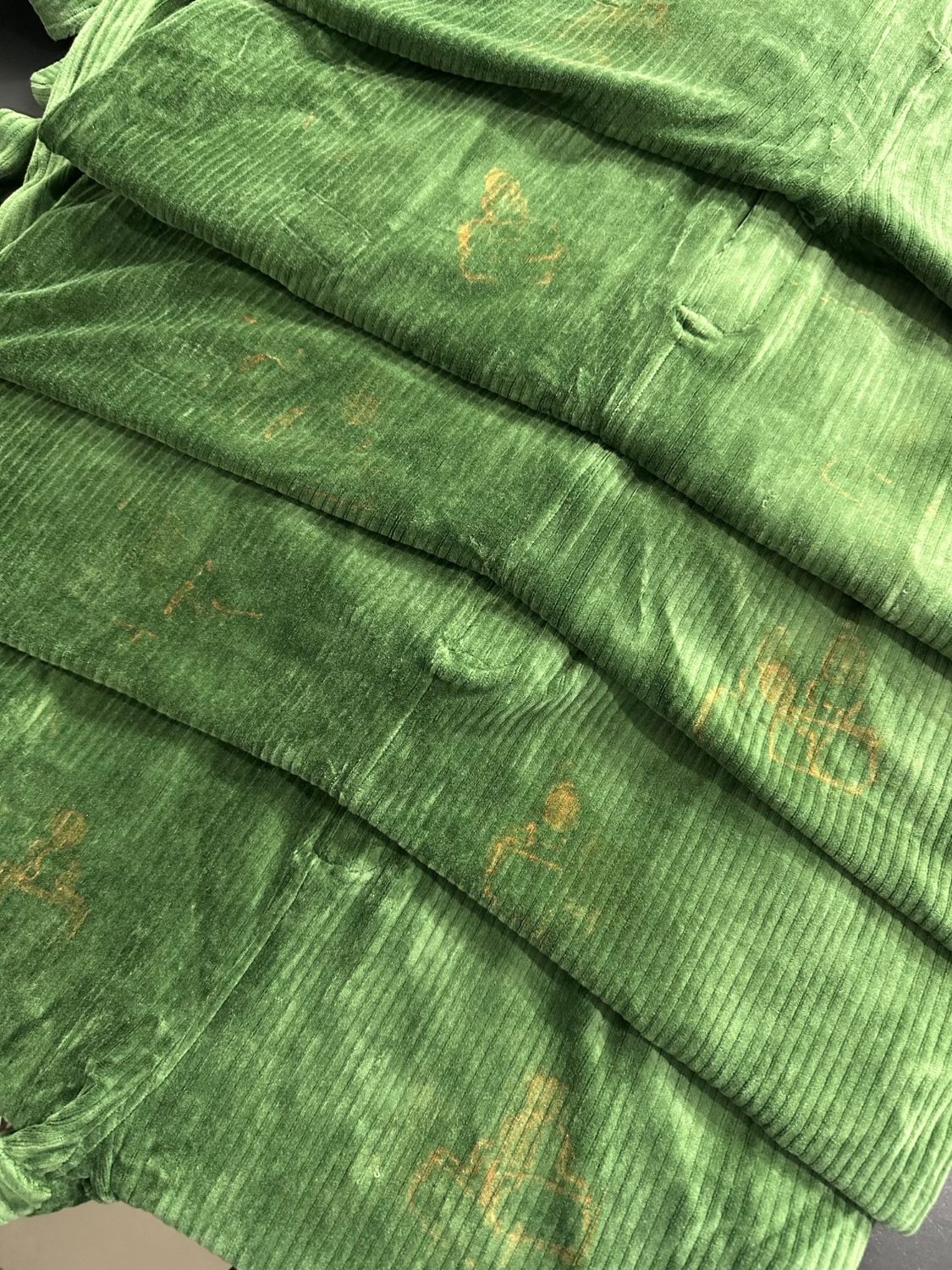 Perfectly Imperfect Forest Green corduroy Swoveralls laid flat showing random rust-colored marks