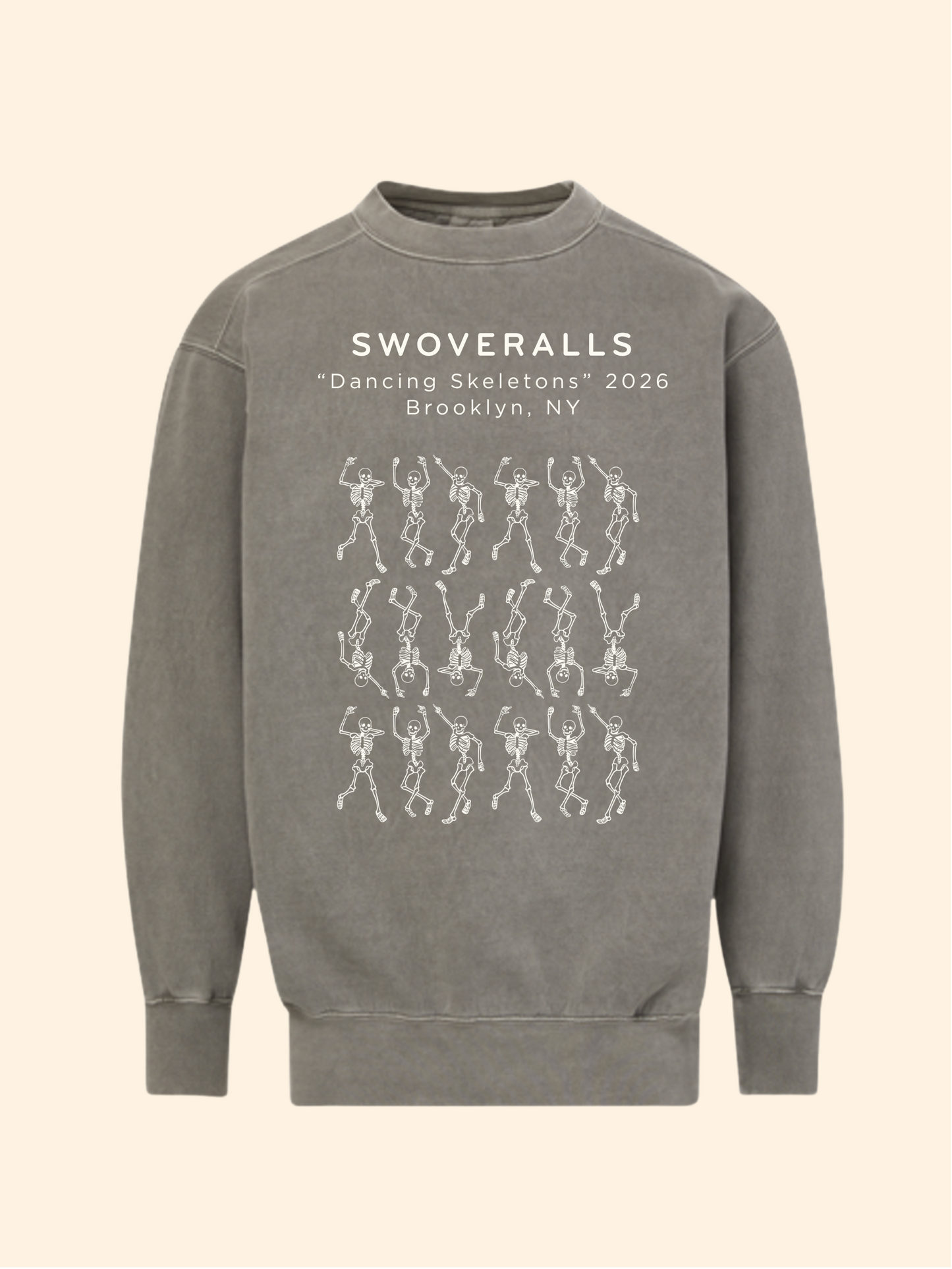 A gray crewneck sweatshirt featuring white printed text that reads 'SWOVERALLS "Dancing Skeletons" 2026 Brooklyn, NY' above a grid of white skeleton dancers, shown on a solid cream background.