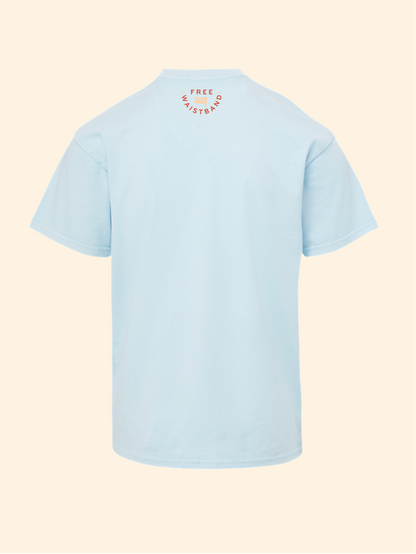 A light blue short-sleeve t-shirt shown from the back, featuring a small circular orange graphic on the upper back with the text 'FREE MYSTERY'. The shirt is displayed against a solid pale cream background.
