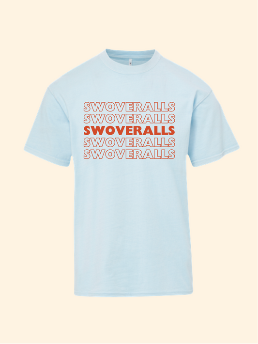 A light blue crewneck t-shirt featuring the word 'SWOVERRALLS' repeated vertically in orange and outlined text on the chest, displayed against a solid pale beige background.